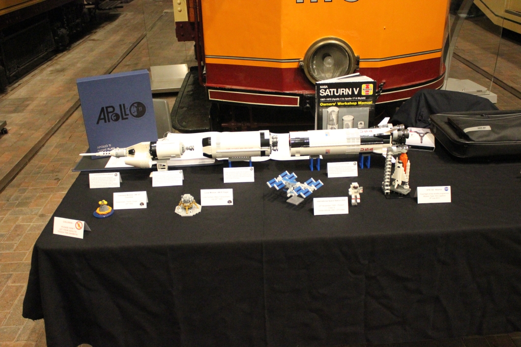 a display of space items including a Saturn V model amongst other related items