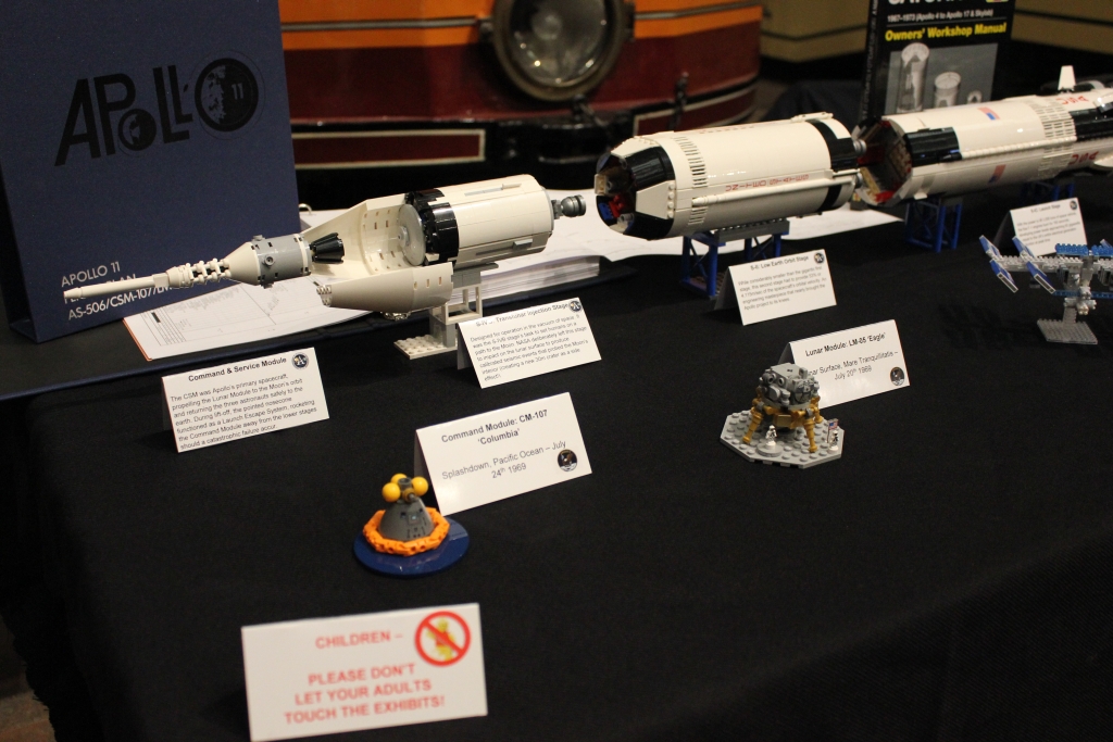 a display of space items including a Saturn V model amongst other related items
