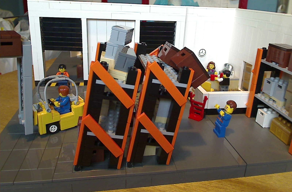 Side view of my LEGO warehouse showing the shelves tilting back as the forklift truck backs into them, causing the crates to fall from them.